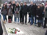 Studenten aus Brügge gedenken der verstorbenen Angehörigen mit Rosen und Namenslesung.